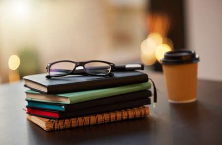 Knowledge is power. Shot of a stack of books on a table in a office.の写真素材