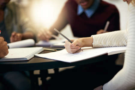 Only a few last minute changes. Shot of a group of unrecognizable people making notes on paper while...