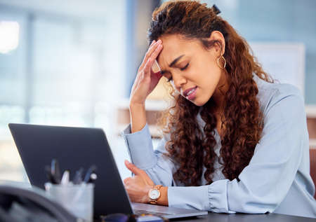 Its a little daunting. Cropped shot of an attractive young businesswoman suffering with a headache...