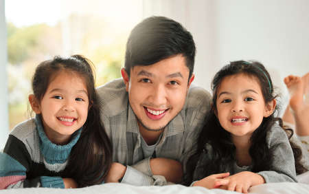 I love spending time with my girls. Shot of a man spending time with his two daughters at home.の写真素材