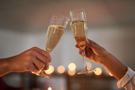 Toasting to some amazing times together. Closeup shot of an unidentifiable couple toasting with glasses of wine.の写真素材