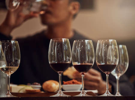 My palate is experiencing a plethora of flavors and aromas. Shot of a man enjoying a cheese platter and tasting different wines.の写真素材