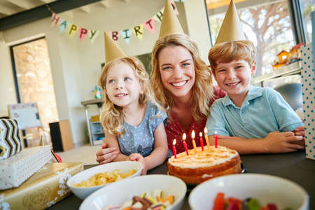 These are the moments to cherish. Portrait of a mother and her two kids having a birthday party at...