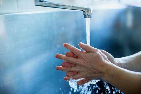 Hygiene first. Cropped shot of a surgeon sterilizing her hands as part of a surgical routine.の写真素材