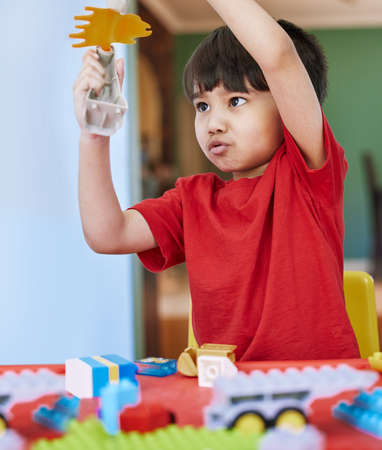 Children look at everything and see the magic. Shot of an adorable little boy playing with toys at...