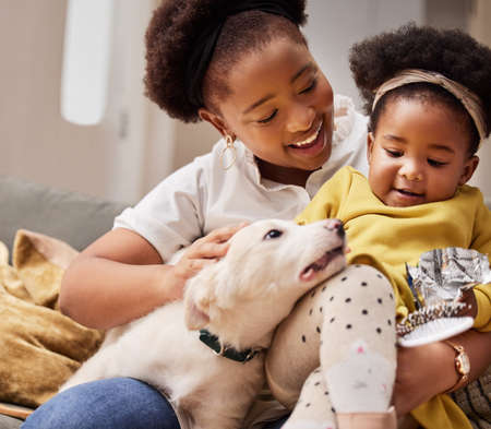 He completes our family. Shot of a young mother and daughter relaxing with their pet at home.の写真素材