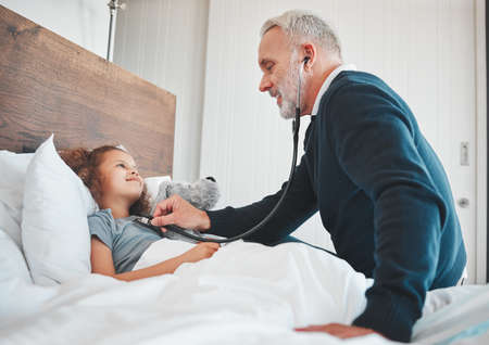 Youre a healthy little girl. Shot of a doctor doing a checkup on a little girl at home.の写真素材