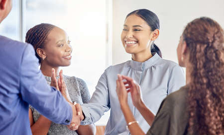 Thank you for the warm welcome. Shot of a young businesswoman shaking hands with a colleague in an...
