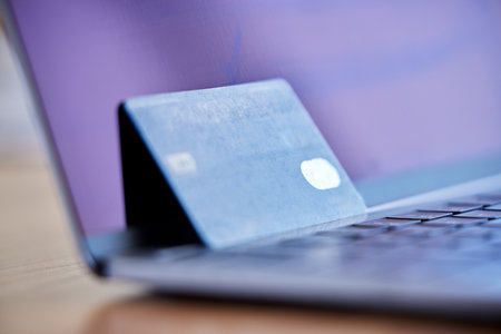 Invest in your future. Shot of a credit card and laptop on a desk in an empty office during the day.