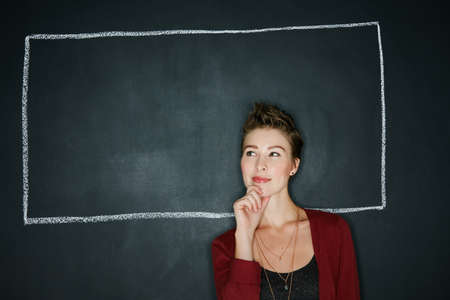 Thoughts can frame who you are. Studio shot of a thoughtful young woman posing with a chalk...