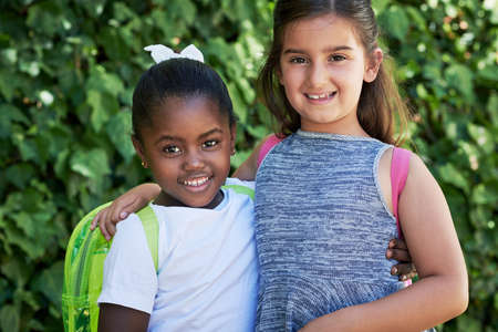 Friends forever. Shot of two little girls wearing backpacks outside in nature.