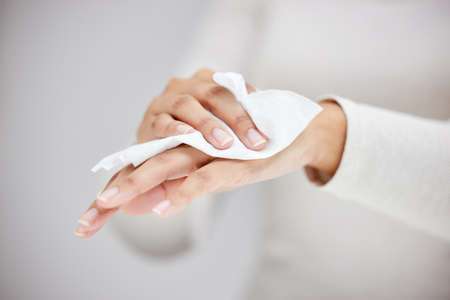 Wiping the germs away. Shot of an unrecognizable person using a wipe to clean their hands.