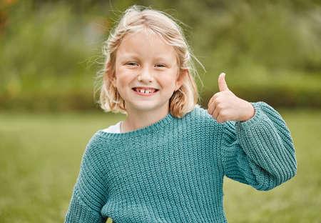 Its all good. Shot of an adorable little girl showing thumbs up while standing outside.