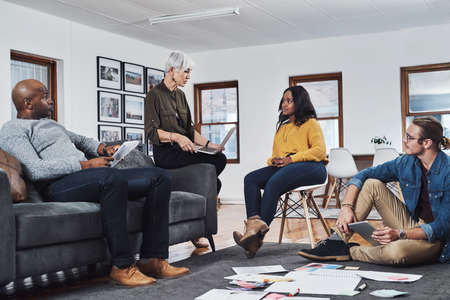 Filling the room with ideas and plans. Shot of a group of businesspeople having a meeting and...