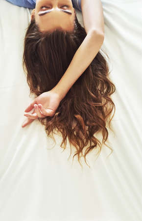 Sleeping beauty. High angle shot of an attractive young woman asleep on her bed.の写真素材
