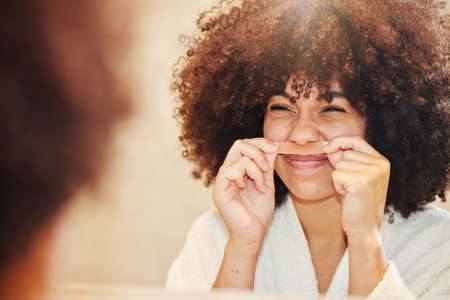 Its so painful but so necessary. Shot of a young woman using a wax strip on her upper lip.