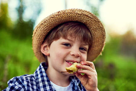 Just stopping for a snack while on my outdoor exploration. Portrait of a little boy enjoying some time outdoors.の写真素材