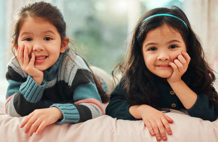 Just chilling with my sister. Shot of two little sisters relaxing at home.