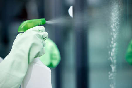 The cleaning solution you use matters. Shot of a woman cleaning her windows.の写真素材