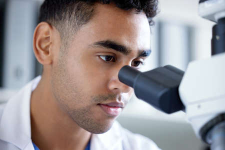What do we have here. Shot of a young man using a microscope in a lab.