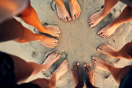 Sandy toes and salty seas is just what we need. Shot of young people hanging out at the beach.の写真素材