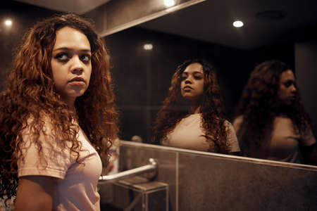 I look to you but I see nothing. Shot of a young female having a mental breakdown at home.の写真素材