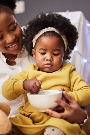 Mommy makes the best food. Shot of a little girl eating breakfast with her mother at home.の写真素材