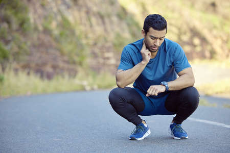 Trying to bring my heart rate back down. Full length shot of a handsome young man crouching and...