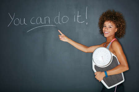 You can have whatever you work for. Shot of a woman holding a scale against a chalk background with...