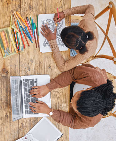 Work and relaxation. Shot of a young mother using a laptop while her daughter does homework at home.