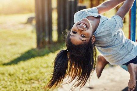Hang on for the ride of your life. Cropped portrait of an adorable little girl playing on a merry-go-round at the park.の写真素材