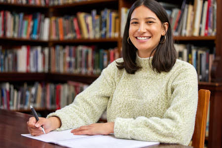 Libraries always remind me that there are good things. Shot of a young woman studying in a college...