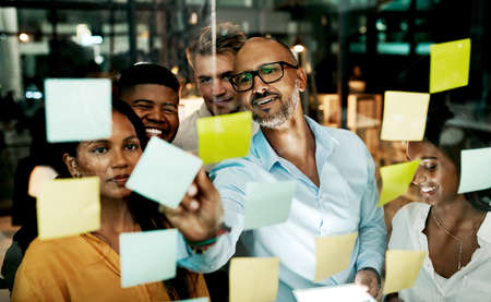 Transforming business into a marketing machine. Shot of a group of businesspeople having a late night brainstorming session in a modern office.の写真素材