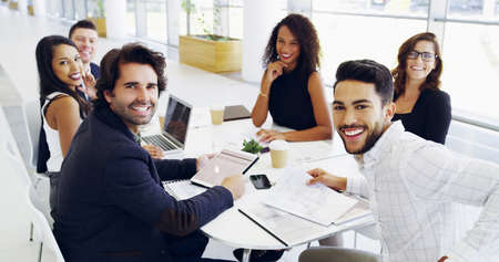 Cropped shot of a group of businesspeople sitting around the boardroom table during a meeting