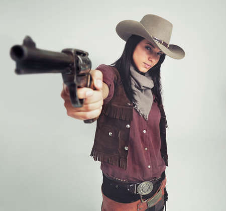 Im the sheriff around these parts.... Full-length shot of an attractive young woman in cowboy attire.の写真素材