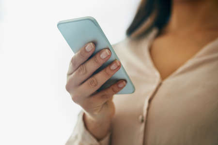 The smarter side of communication. Closeup shot of an unidentifiable businesswoman using a cellphone in an office.の写真素材