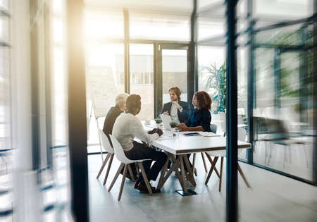 Developing winning strategies together. Shot of a group of businesspeople having a boardroom meeting...