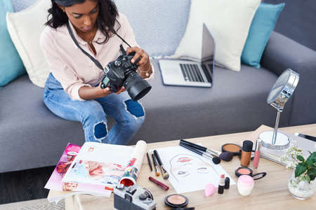Showing my followers the tools I use. Cropped shot of an attractive young woman working at home.の写真素材