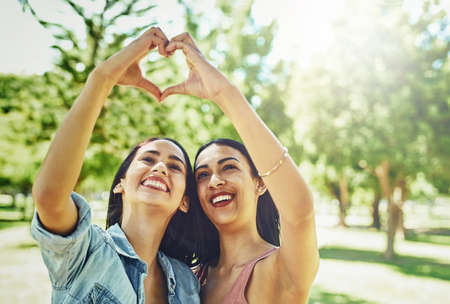 Cant beat that best friend kinda love. Shot of two happy young friends joining their hands to make a heart shape.の写真素材