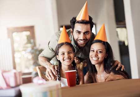 Hip hip hooray, its someones birthday. Shot of a happy mother and father celebrating their daughters birthday at home.の写真素材