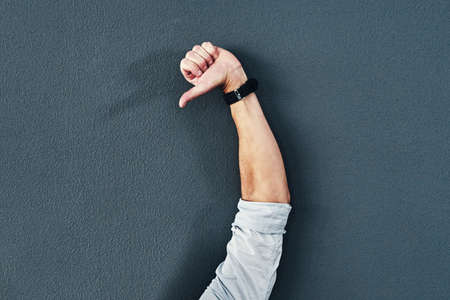 Express yourself. Studio shot of an unrecognizable man raising his hand against a grey background.