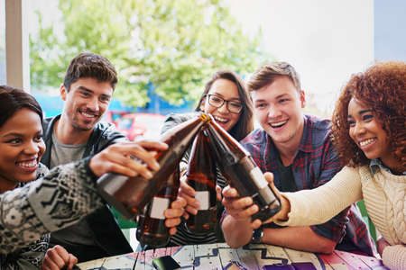 To the crew. Cropped shot of a group of friends hanging out and drinking beers.の写真素材