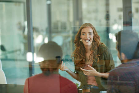 Letting them in on her plan. Shot of a team of creative businesspeople having a meeting in their...