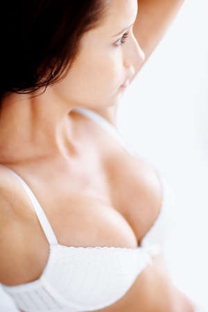 Busty lingerie model against white. Sexy woman in white lingerie against white background.の写真素材