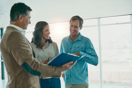 The excitement grows. Shot of a group of businesspeople discussing ideas in the new office space for...
