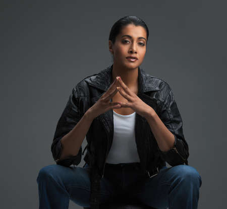 Poised and perfect. Studio shot of a beautiful young woman posing against a dark background.