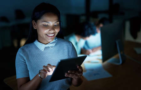 Whatever the night has in store, shell handle it. Shot of a young businesswoman using a digital...