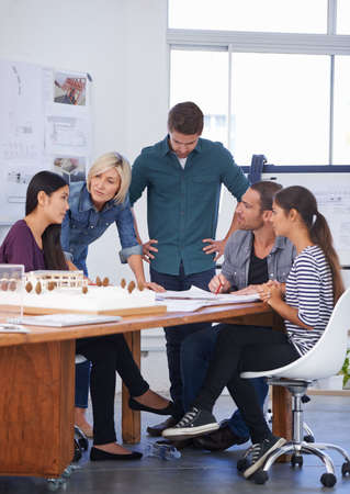 They listened intently to her solution. Cropped shot of a group of architects discussing a scale...