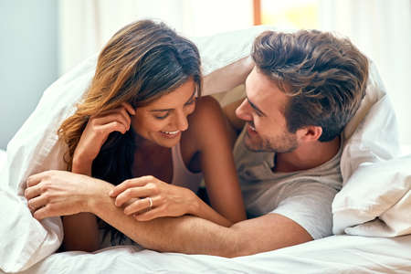 Its that cosy kinda love. Shot of a loving young couple spending a relaxing morning at home.の写真素材