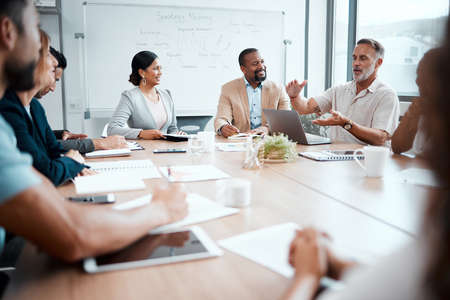 Scaling down will help our budget. Shot of a group of staff listening to their boss during a...
